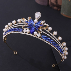 Macro detail of bridal tiara with blue marquise crystals, pearls, and gold alloy frame