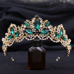 Detailed macro view of a gold bridal crown with emerald gems and intricate vine patterns