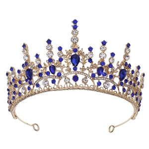 Détail macro d'une couronne dorée vintage avec cristaux bleu marine et motifs en métal ajouré
