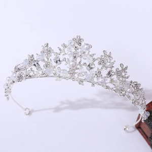 Detailed close-up of a silver bridal crown with pearls and floral rhinestone patterns