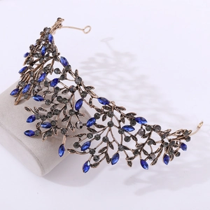 Macro detail of Baroque bronze crown featuring vintage leaves and deep blue rhinestones
