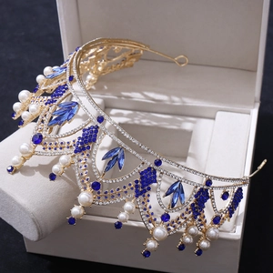 Vue détaillée d'une couronne de mariée dorée avec strass bleu foncé et perles blanches