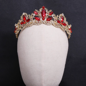 Close-up of vintage baroque crown with red crystals and white rhinestones on gold alloy