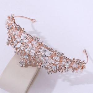 Close-up of rose gold bridal headband with rhinestones and pink crystal leaf details