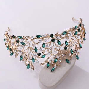 Macro view of gold vine bridal crown with green crystals and white zircon leaf details
