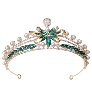 Detail of bridal crown with green marquise stones, white pearls, and gold foliage base