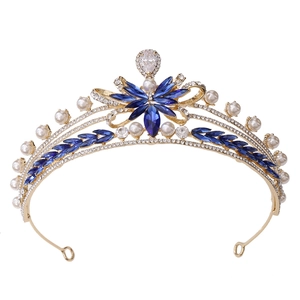 Detailed macro of a gold bridal crown with dark blue gems, clear crystals and white pearls
