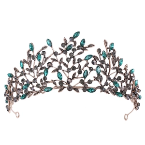 Detailed macro view of baroque vintage leaf crown with emerald and gray crystals