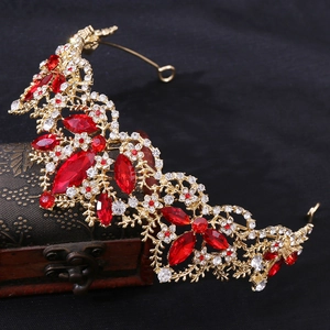 Macro detail of royal gold bridal crown with red marquise gems and crystals