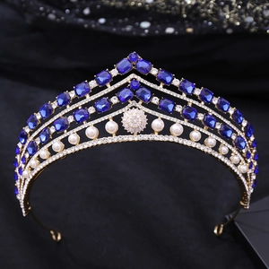 Détail de diadème doré de luxe avec pierres précieuses bleu foncé, perles et cristaux
