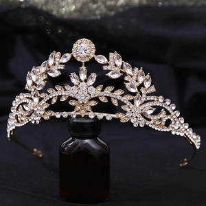 Elegant gold bridal crown with zircon leaf patterns and sparkling crystals on black background