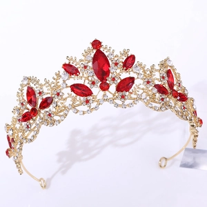 Close-up of a vintage golden bridal crown with red rhinestones and crystal details