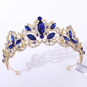 Elegant gold crown headpiece with blue gemstones and white rhinestones on white background