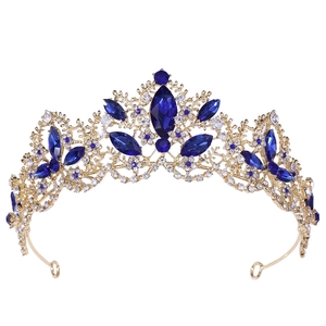 Macro detail of royal gold crown featuring luxury navy blue crystals and shimmering rhinestones