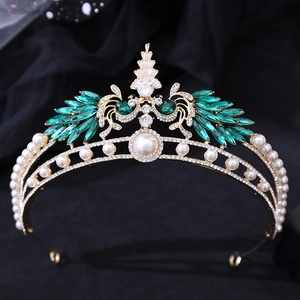 Detailed macro view of the gold crown with white pearls and green marquise gemstones