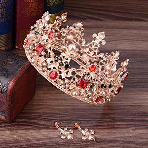 Close-up of vintage baroque bridal crown and earrings with red rhinestones and pearls