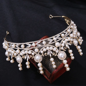 Vue détaillée d'une couronne de mariée dorée avec perles blanches sur boîte vintage