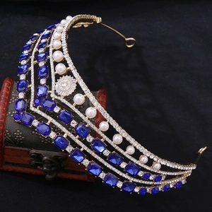 Vue détaillée d'une couronne de mariée dorée avec gemmes bleu foncé et perles blanches