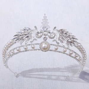 Detailed view of silver peacock crown featuring white pearls and sparkling rhinestones