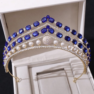 Détail d'une couronne de mariée baroque dorée avec pierres bleues et perles dans un écrin