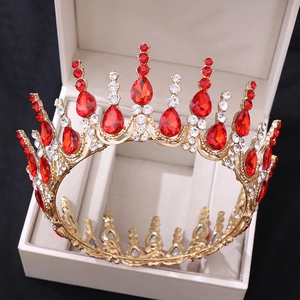 Détail d'une couronne dorée de luxe avec zircons rouges et cristaux dans son coffret