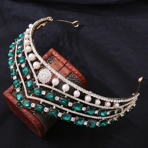 Détails de la couronne baroque dorée avec cristaux émeraude et perles blanches