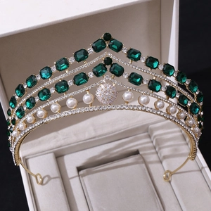 Détail macro d'une couronne baroque rouge avec gemmes émeraudes et perles en boîte à bijoux