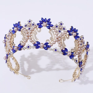 Close-up of luxury Baroque bridal crown with blue crystals and white pearls on gold