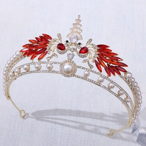 Detailed side view of luxurious golden peacock wedding crown with red crystals and pearls
