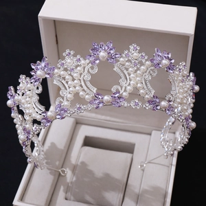 Detail of luxury baroque bridal crown with purple crystals and pearls in a white jewelry box
