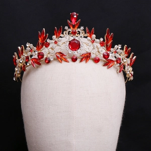 Gros plan sur une couronne baroque dorée avec cristaux rouges de luxe et strass