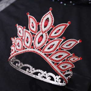 Detailed close-up of a silver baroque crown with red crystals and sparkling rhinestones