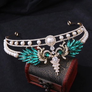Macro detail of royal crown with green marquise crystals and pearls on vintage box