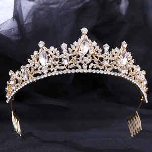Detail of gold floral bridal tiara with rhinestones and comb on black fabric