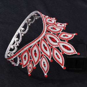 Close-up of luxury Baroque crown featuring red rhinestones and silver leaf patterns