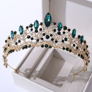 Detail of rose gold crown featuring emerald green marquise crystals and intricate metalwork