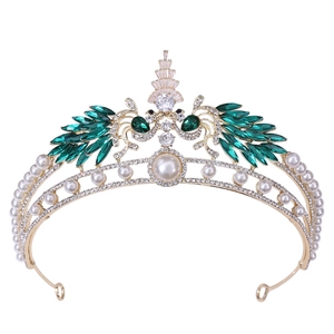 Detailed view of luxury bridal crown featuring emerald stones and white pearls