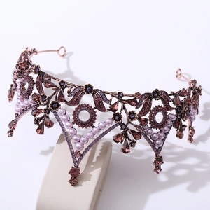 Detail of vintage bronze tiara featuring purple crystals and elegant leaf motifs