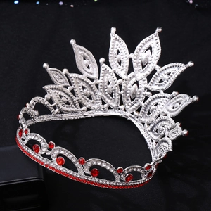 Detailed macro view of ornate silver alloy tiara with red rhinestones and floral hollow design
