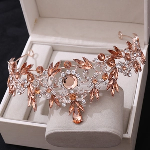 Détail d'une couronne de mariée en or rose avec cristaux champagne et motifs de feuilles