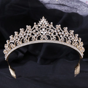 Macro view of gold baroque tiara with crystal flower cluster on black fabric