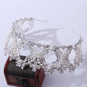Macro view of silver luxury baroque bridal crown featuring crystal and pearl flower details