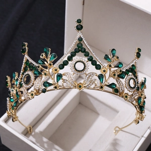 Detailed macro view of a luxury gold bridal crown with green crystals and white rhinestones