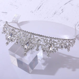 Elegant silver bridal tiara with leaf motif crystals and rhinestones on white pedestal