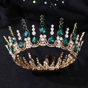 Détail d'une couronne dorée vintage avec pierres vert émeraude et diamants blancs