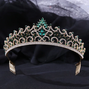 Close-up of golden crown with intricate hollow patterns and dark green crystals