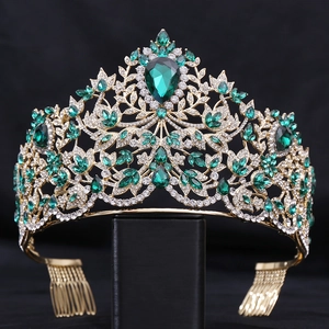 Detailed close-up of Baroque crown with emerald crystals and gold leaf patterns