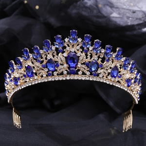 Close-up of golden leaf tiara with green crystal and intricate baroque bridal details