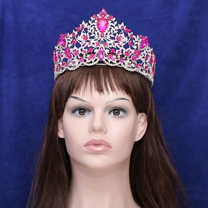 Close-up of silver baroque crown with pink heart gemstone and sparkling crystals