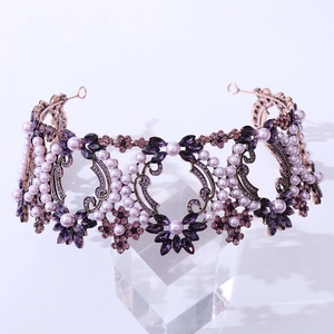 Detailed close-up of Baroque bridal crown with purple crystals and pearls on rose gold frame